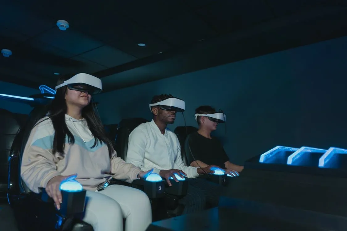 Tres personas con visores de realidad virtual y mandos de juego