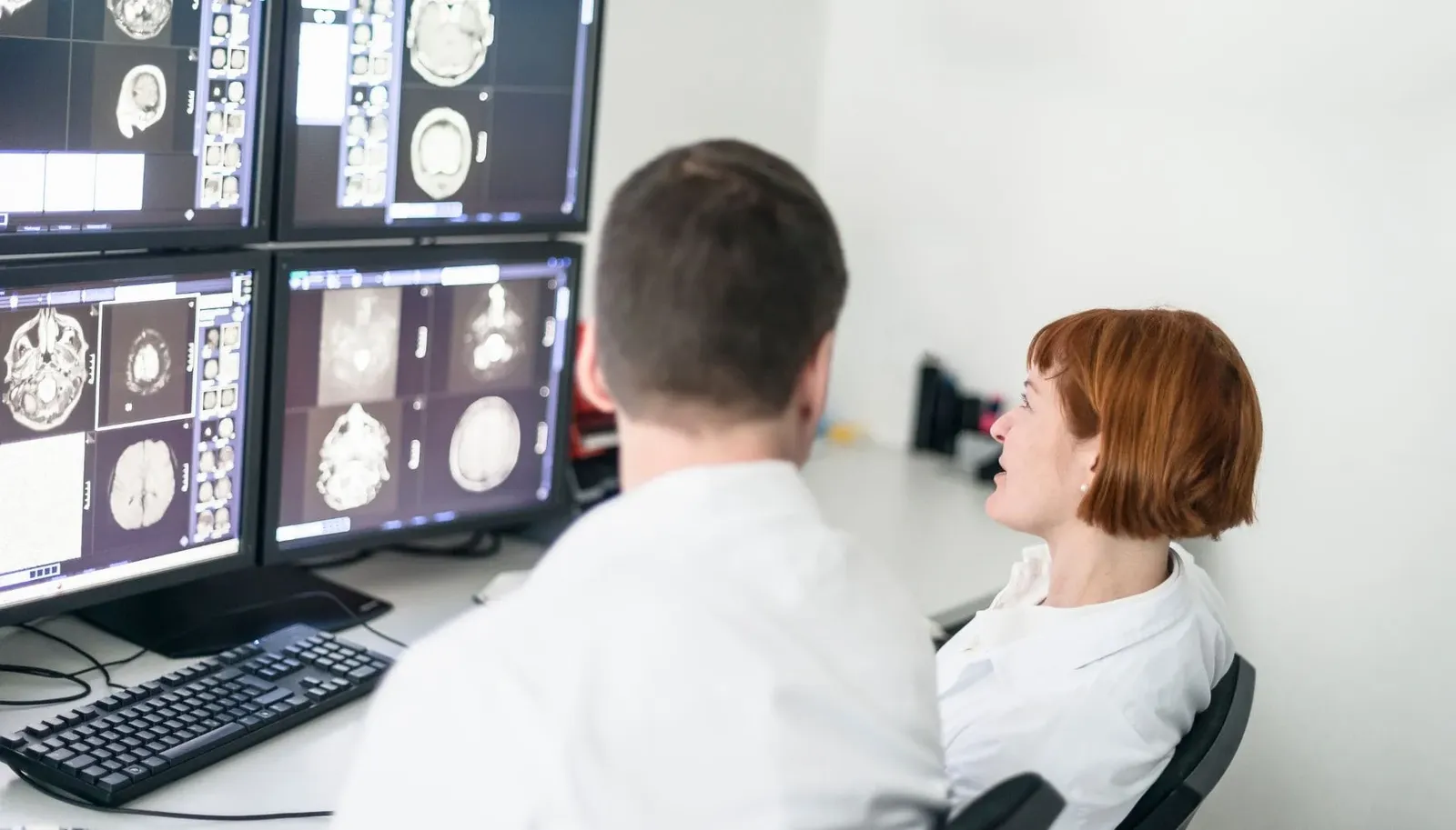 Dos médicos observando escáneres cerebrales en una sala de diagnóstico