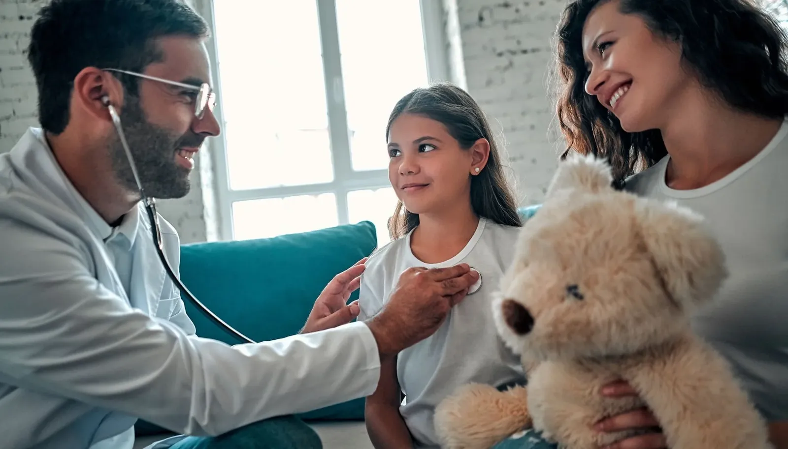 Médico con estetoscopio atendiendo a una madre y su hija