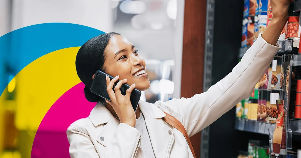 Clienta sonriente usando el móvil en una tienda