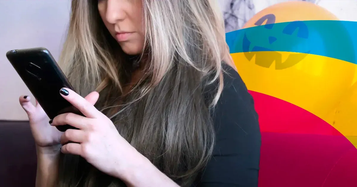 Mujer consultando el móvil frente a un fondo de colores